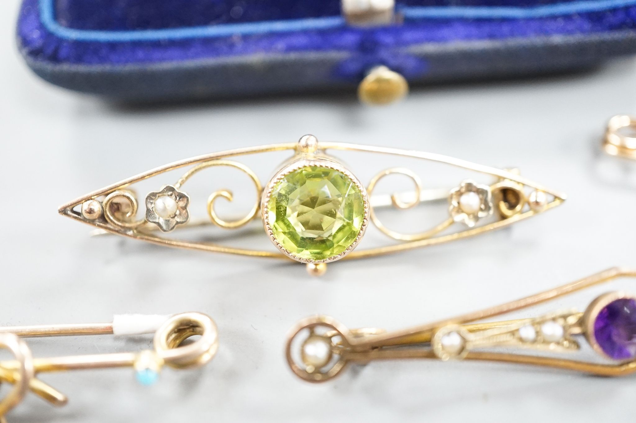 Five assorted early 20th century yellow metal and gem set brooches, including one 9ct and one with turquoise set heart drop and one with peridot, largest 62mm, gross 11.7 grams.